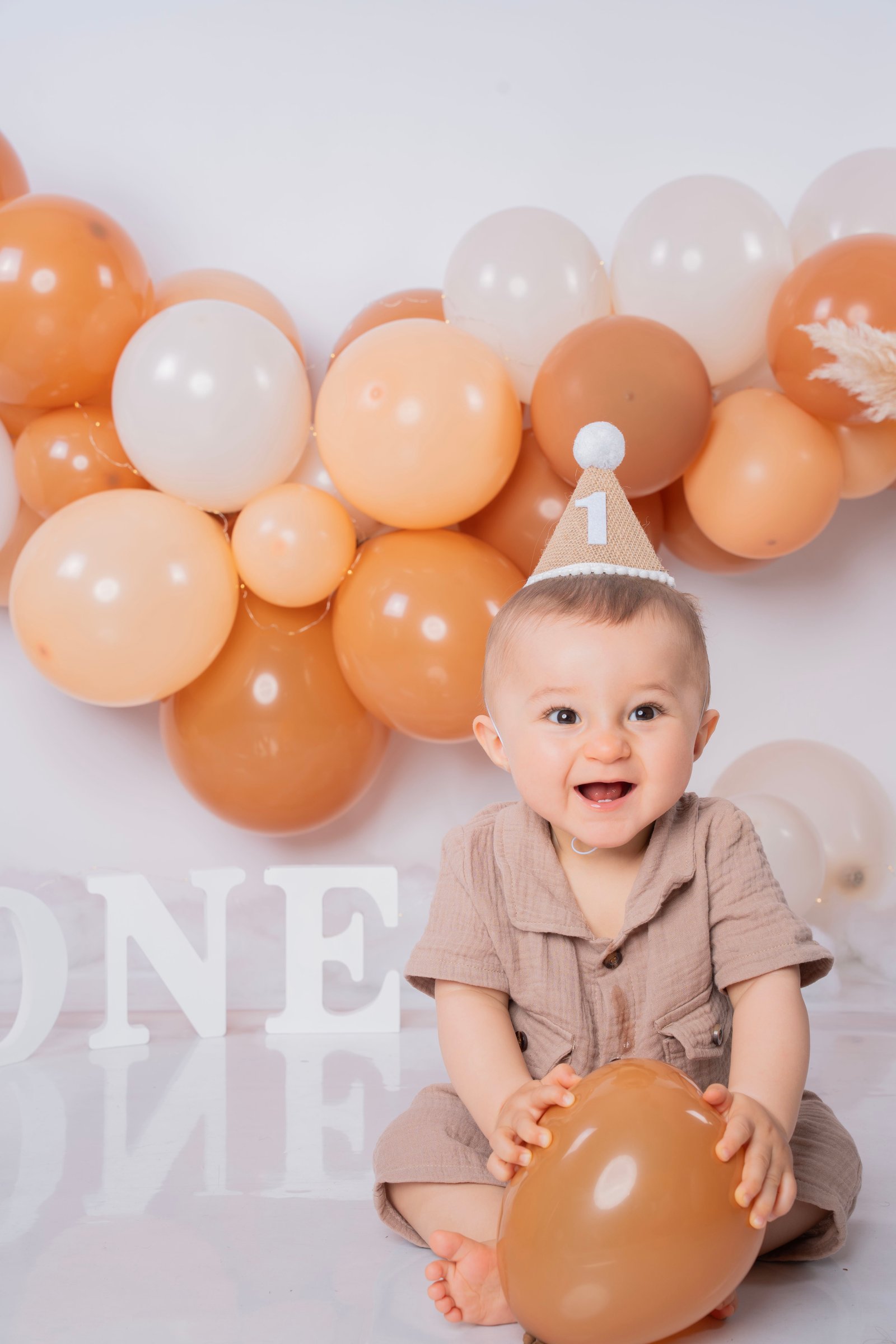 Bébé souriant tenant un ballon lors d'une séance photo famille