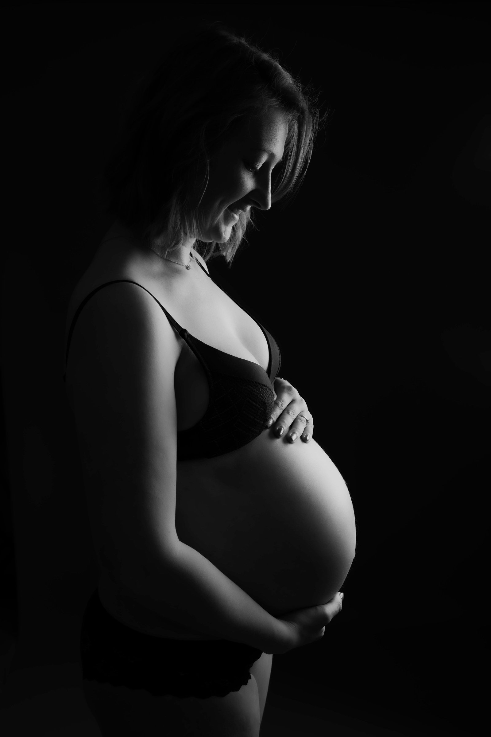 Future maman en studio, portrait de grossesse en noir et blanc