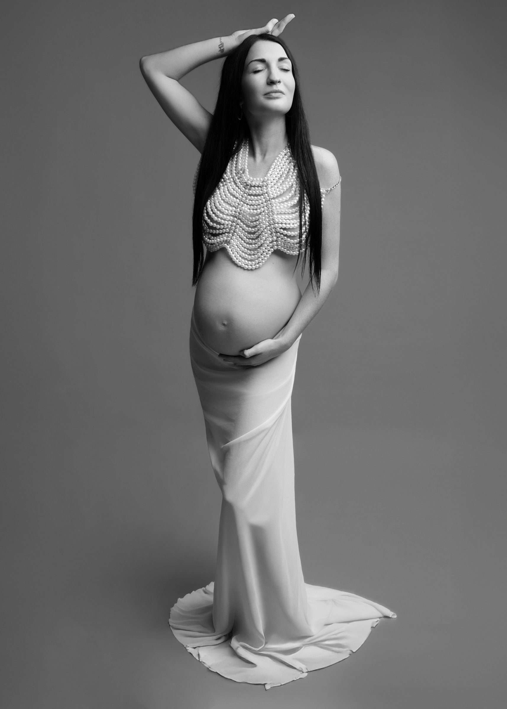 Future maman posant en noir et blanc lors d'une séance photo grossesse