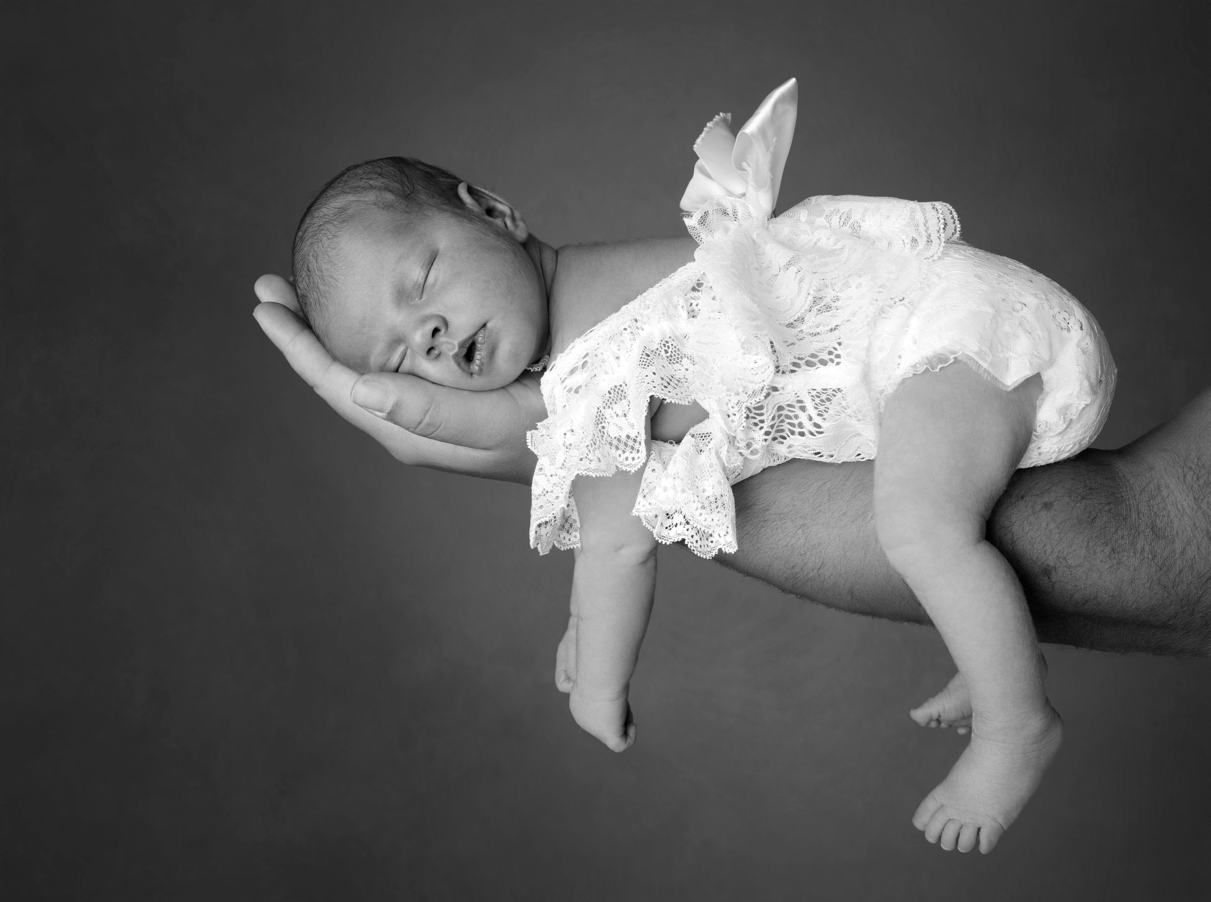 Nouveau-né endormi lors d'une séance photo naissance en noir et blanc
